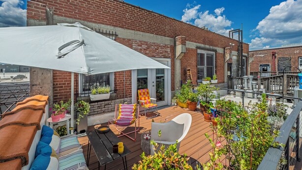 A patio with outdoor furniture, a white umbrella, and potted plants. - Bright and airy loft space 10 min walk from stadiums with private roof terrace (Atlanta)