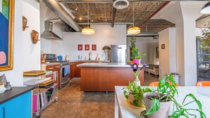 A modern kitchen with a central island, stainless steel appliances, and pendant lighting. - Bright and airy loft space 10 min walk from stadiums with private roof terrace (Atlanta)