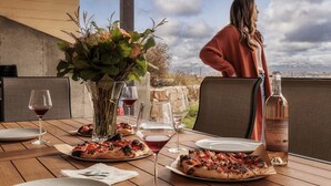 Ett matbord med pizzor, vinglas och en vinflaska.