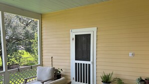 A porch with a bench, a door, and potted plants. - The Lone Start Suite on the Mississippi River in Donaldsonville (Donaldsonville)