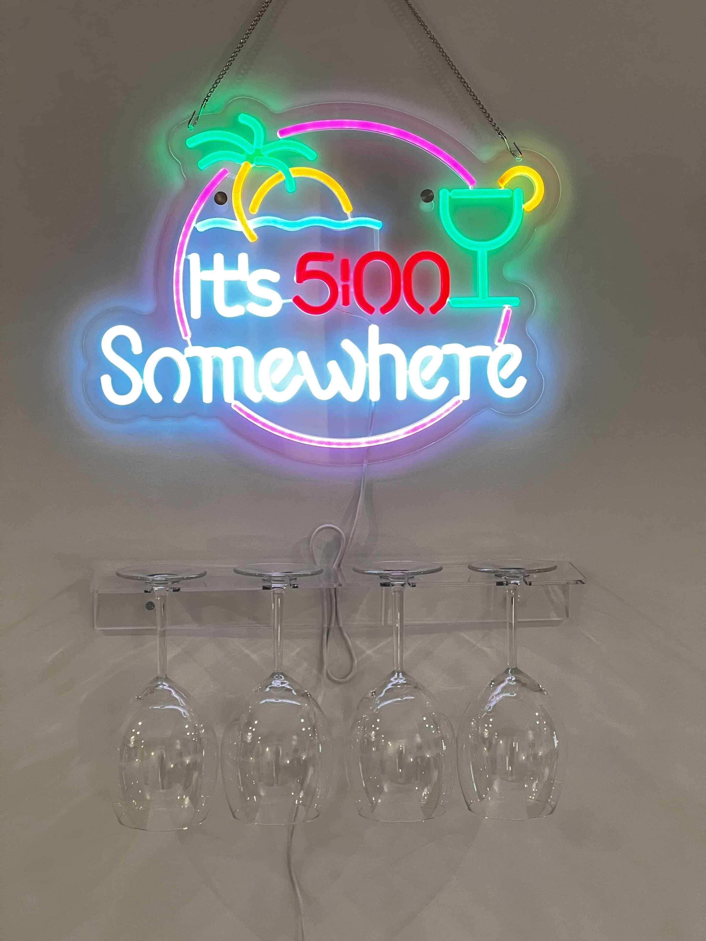 Un letrero de neón con el texto 'It's 5100 Somewhere' y cuatro copas de vino colgando debajo.