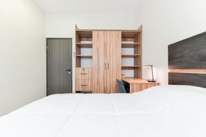 Une chambre à coucher avec un lit, un bureau et une armoire.