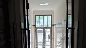 An interior corridor with a glass door leading to an outdoor area. - „Modern apartment 5 min from metro Anděl – fast WiFi“ (Praha)