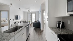Una cocina moderna con encimeras de granito, lavavajillas integrado y cafetera.