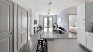 Una cocina moderna con una isla central, un comedor y vistas al exterior.