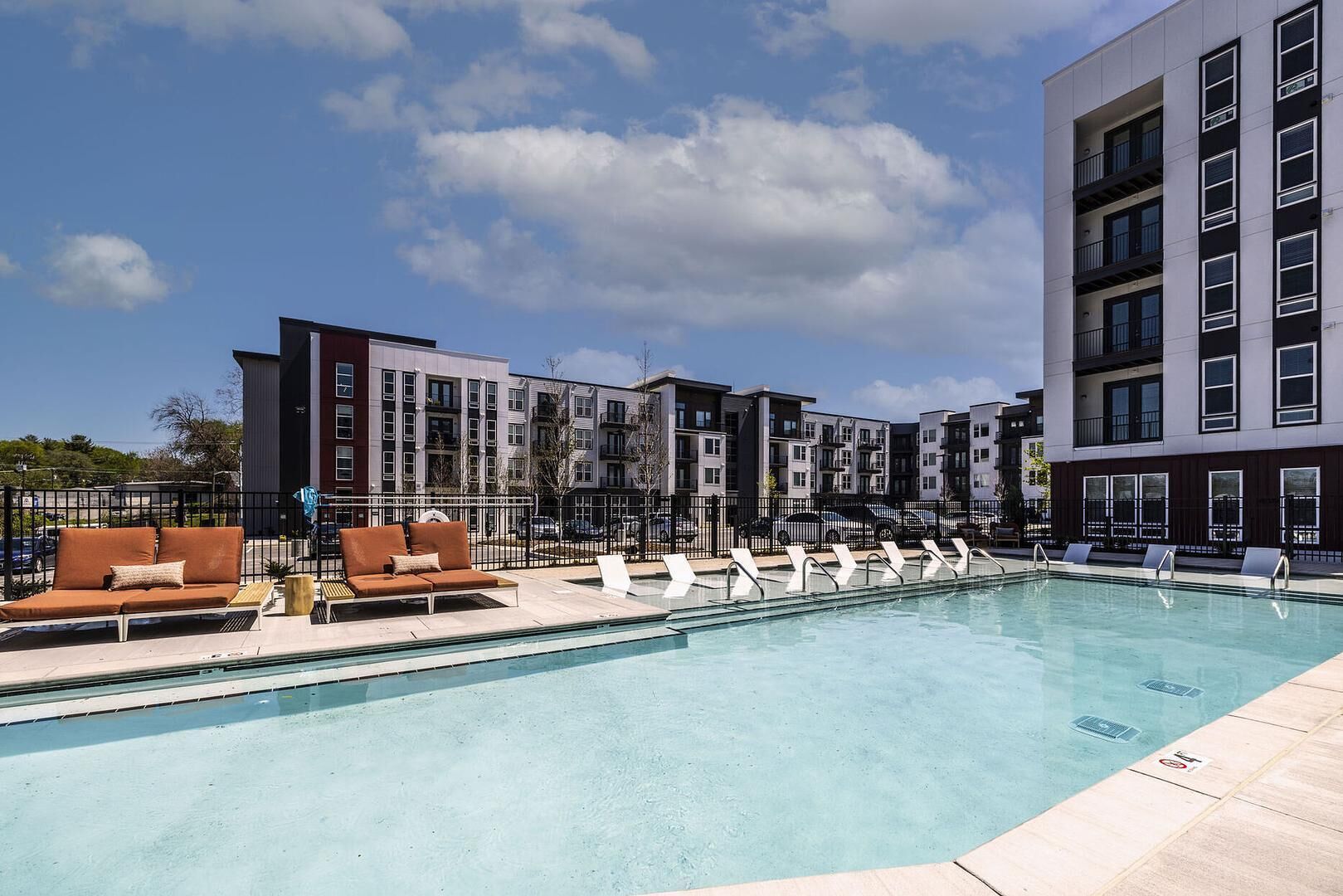 A modern outdoor pool area with lounge chairs and a poolside seating area.