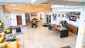 A spacious living area with a kitchen, a dining area, and a seating area with a sofa and chairs. - Landing | Chic Studio, Gym, Yoga Studio (Birmingham)