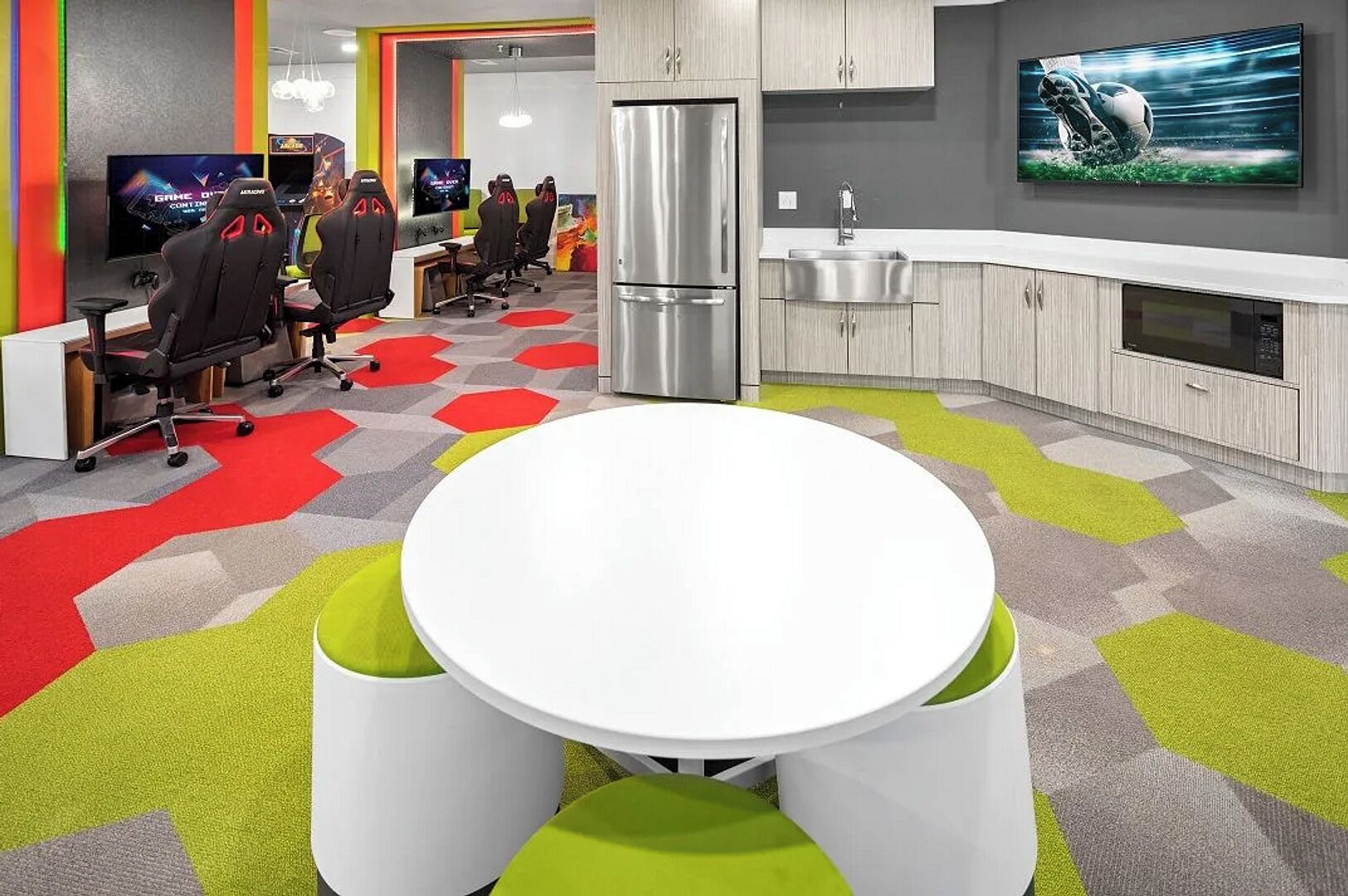 Una cocina moderna con una isla central, electrodomésticos de acero inoxidable y un televisor de pantalla plana montado sobre la encimera.