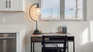 A kitchen with a dining table, a lamp, and a speaker. - Landing | Amazing 2BD in Harvey Park South (Englewood)