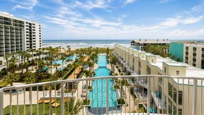 Ein Hotel mit Pool, Palmen und Meerblick.