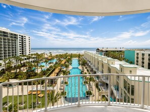 Ein Hotel mit Pool, Palmen und Meerblick.