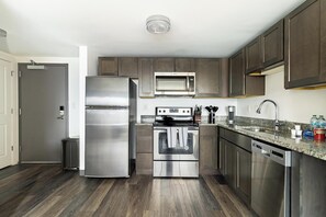 A modern kitchen with stainless steel appliances, a microwave, and a dishwasher. - Landing | Amazing 1BD, Gym, Pool (Hartford)