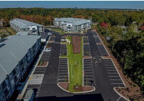 A multi-story parking structure with a central landscaped area, surrounded by buildings with flat roofs. - Landing | Spectacular 2BD, Clubhouse, Gym (Raleigh)