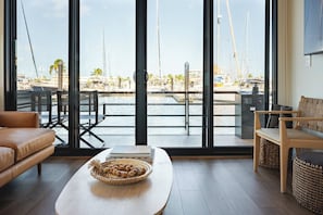 Un saló modern amb un finestra gran que dona a un port esportiu ple de vaixells.