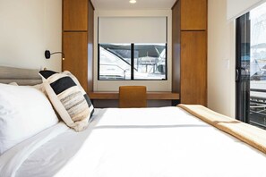 A hotel room with a bed, a desk, and a window with a view of a boat. - Waterfront & Heated Pool - Break Awai Floating Villa (Stock Island)