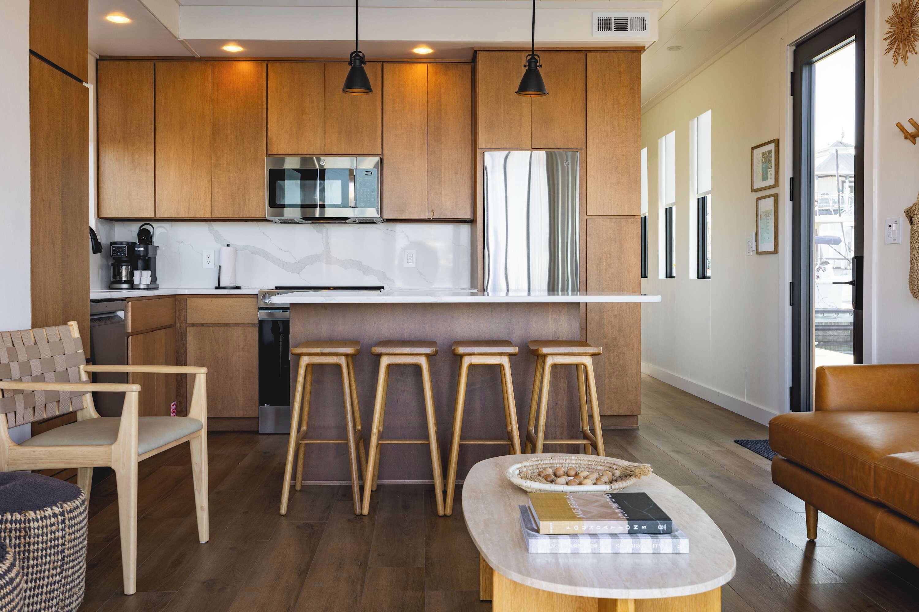 A modern kitchen with wooden cabinets, a stainless steel refrigerator, and a built-in oven.