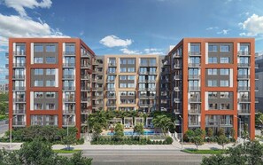 A multi-story residential building with balconies, a swimming pool, and a landscaped area. - Landing | Incredible 1BD, Yoga Studio, Game Room (Miami)