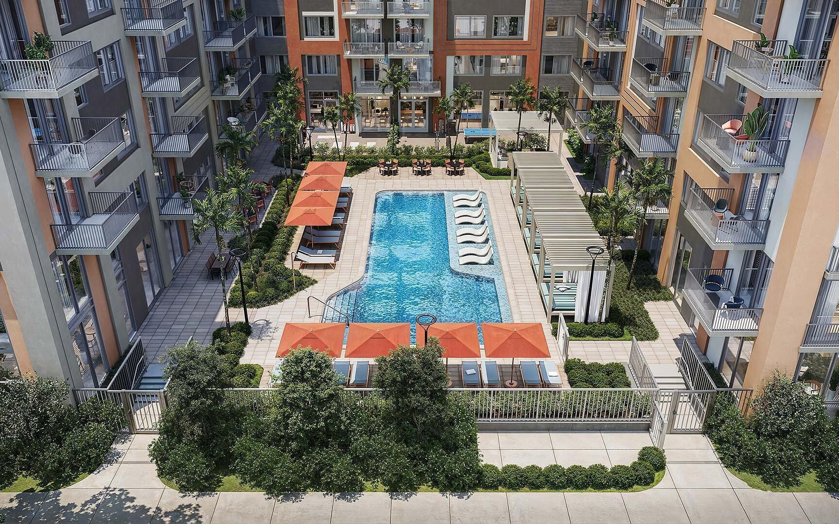A modern apartment complex with a central swimming pool, balconies, and lush greenery.