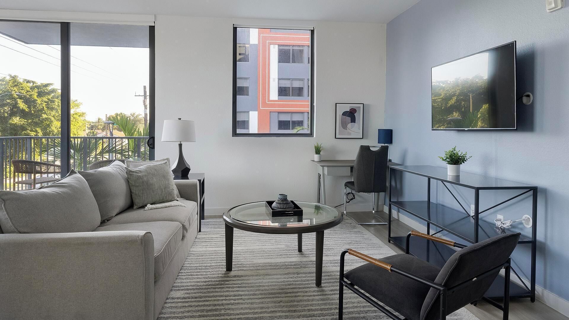 Uma sala de estar moderna com sofá, mesa de centro e televisão.