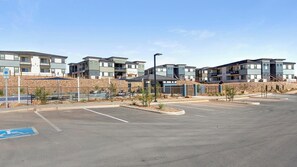 A parking lot with modern apartment buildings in the background. - Landing | Modern 2BD, Pool (Casas Adobes)