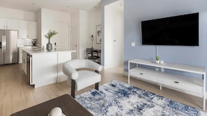 A modern kitchen with white cabinetry, a built-in oven, and a stainless steel refrigerator. - Landing | Incredible 2BD, Pool (Casas Adobes)