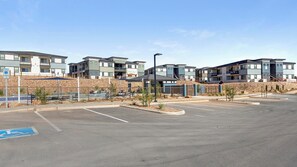 A parking lot with modern apartment buildings in the background. - Landing | Incredible 2BD, Pool (Casas Adobes)