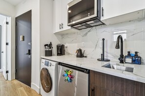 A modern kitchen with a built-in washer, a microwave, and a coffee maker. - 1 Bedroom New Renovated - Wash/Dryer & Kitchenette -G (New York)