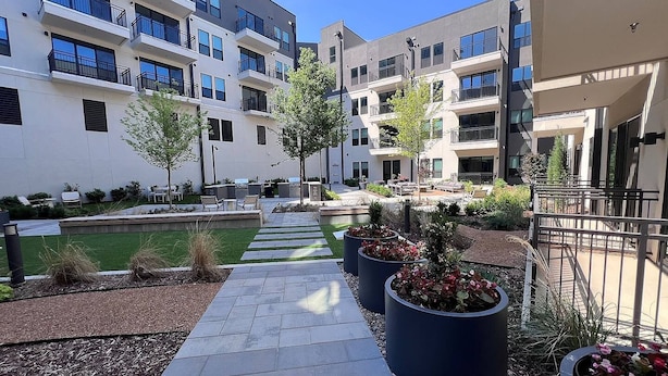 A courtyard with a pathway, outdoor seating, and planters. - Landing | Spectacular 1BD, Clubhouse (Tulsa)