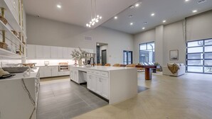 A spacious kitchen with white cabinetry, a central island, and a dining area with a pool table. - Landing | Spectacular 1BD, Clubhouse (Tulsa)