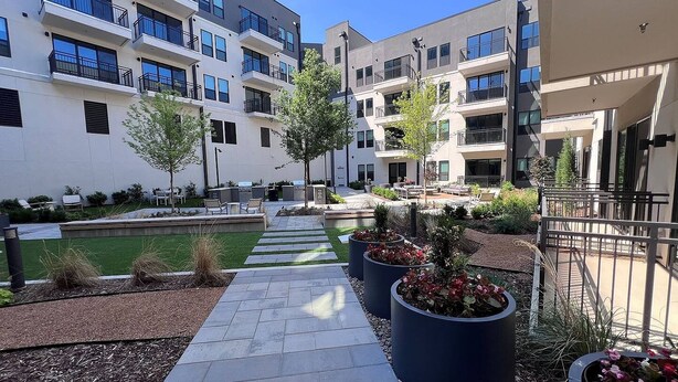 A courtyard with a pathway, outdoor seating, and planters. - Landing | Stylish 1BD, Clubhouse (Tulsa)