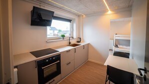 Eine kompakte Küche mit Backofen, Spüle und Fenster mit Blick nach außen.