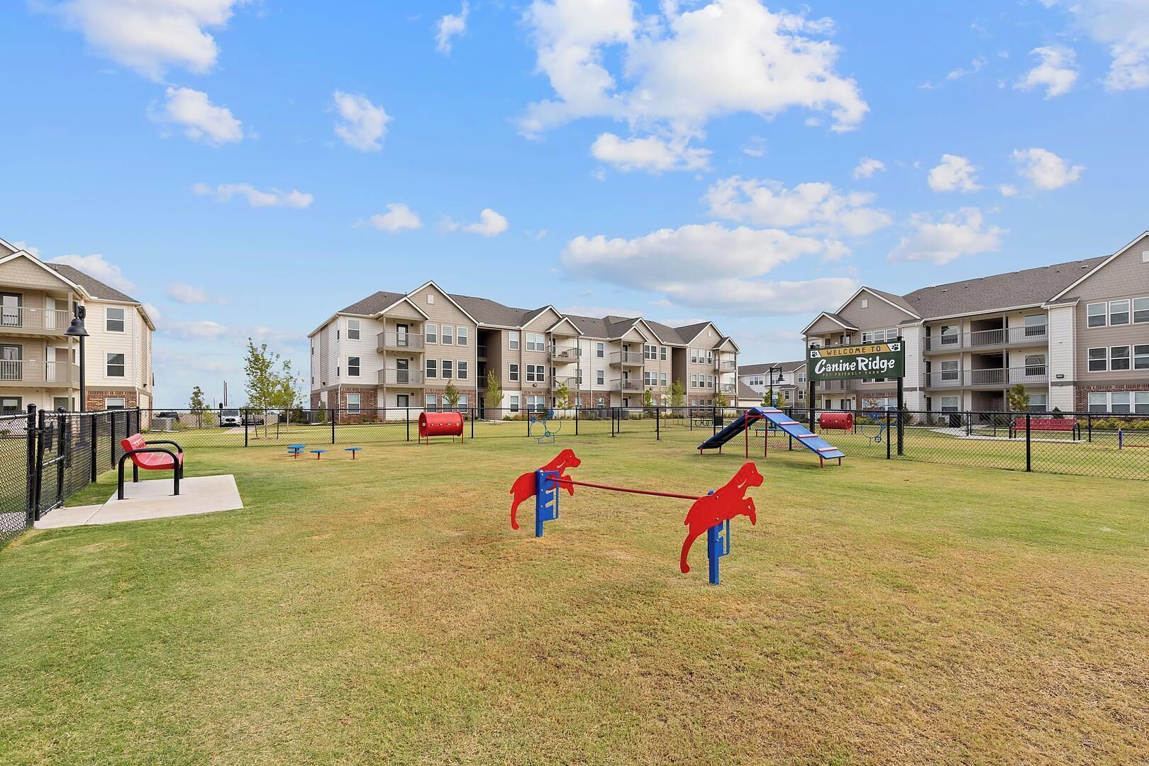 A pet-friendly outdoor area with a dog park, swings, and a slide.