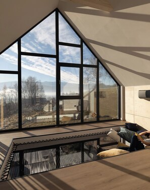 A room with a large window, a low ceiling, and a view of a landscape. - Flowfort View Private Hottub & Sauna Dom Swobodnie (Stara Kamienica)