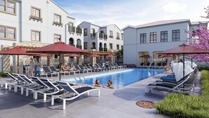 A pool area with sun loungers, umbrellas, and a clear blue pool. - Landing | Chic 2BD, Gym, Game Room (Murrieta)