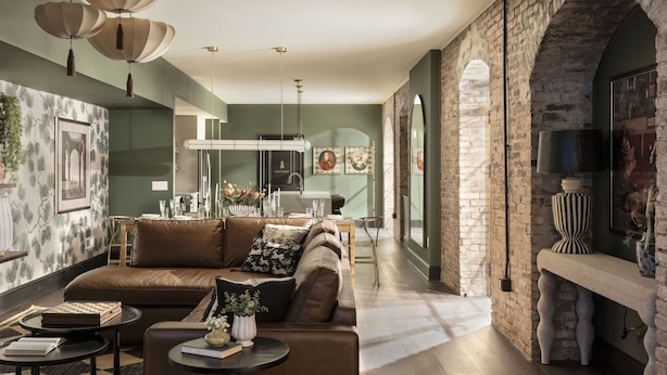 A modern living room with a brown leather sofa, a coffee table, and a fireplace. - Historic Diplomat Suite w/Parking - The Harmony (Philadelphia)