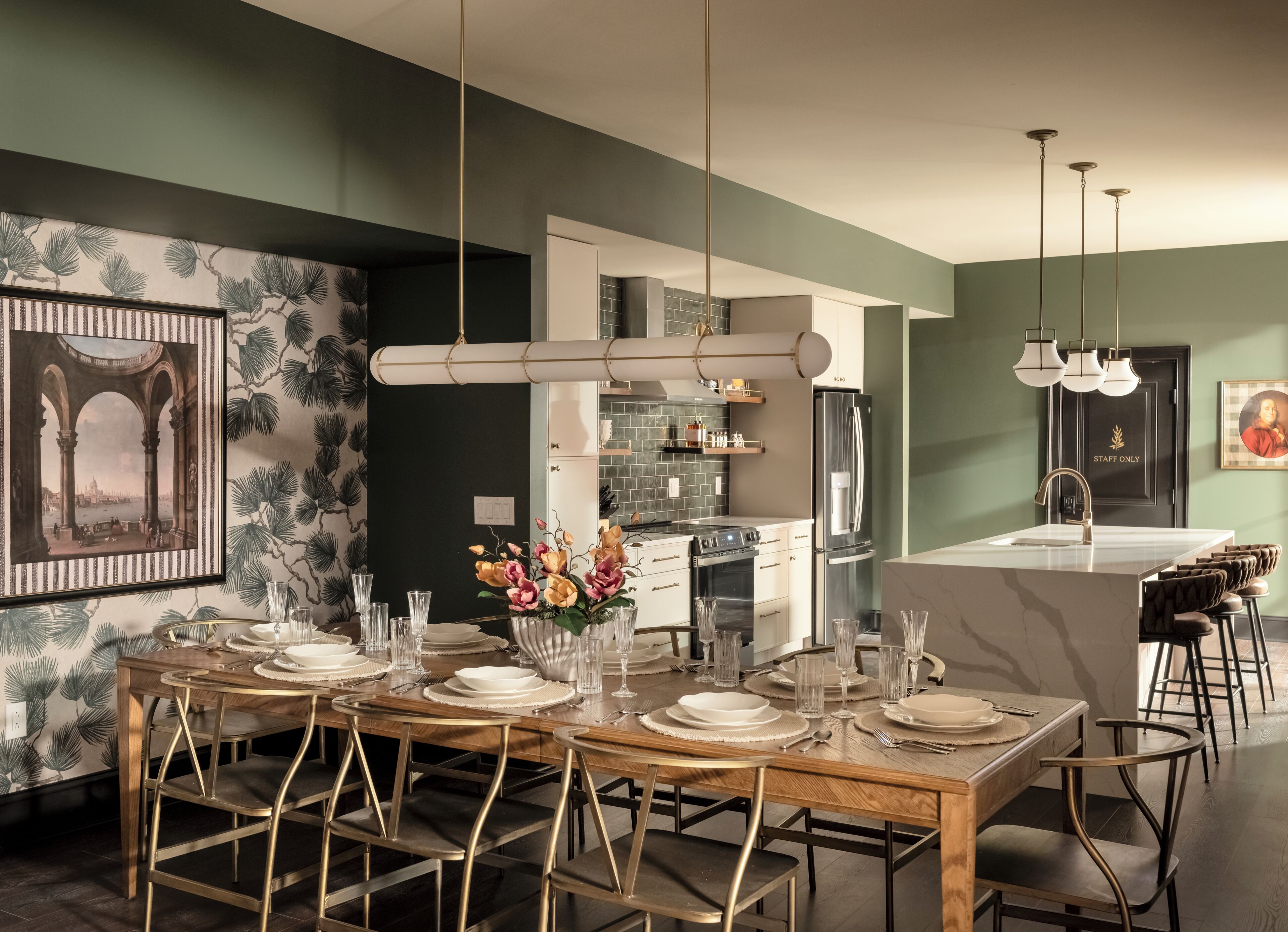 Une cuisine moderne dotée d’un îlot central, d’un coin repas avec une table et des chaises en bois, et d’un comptoir de cuisine avec un réfrigérateur.
