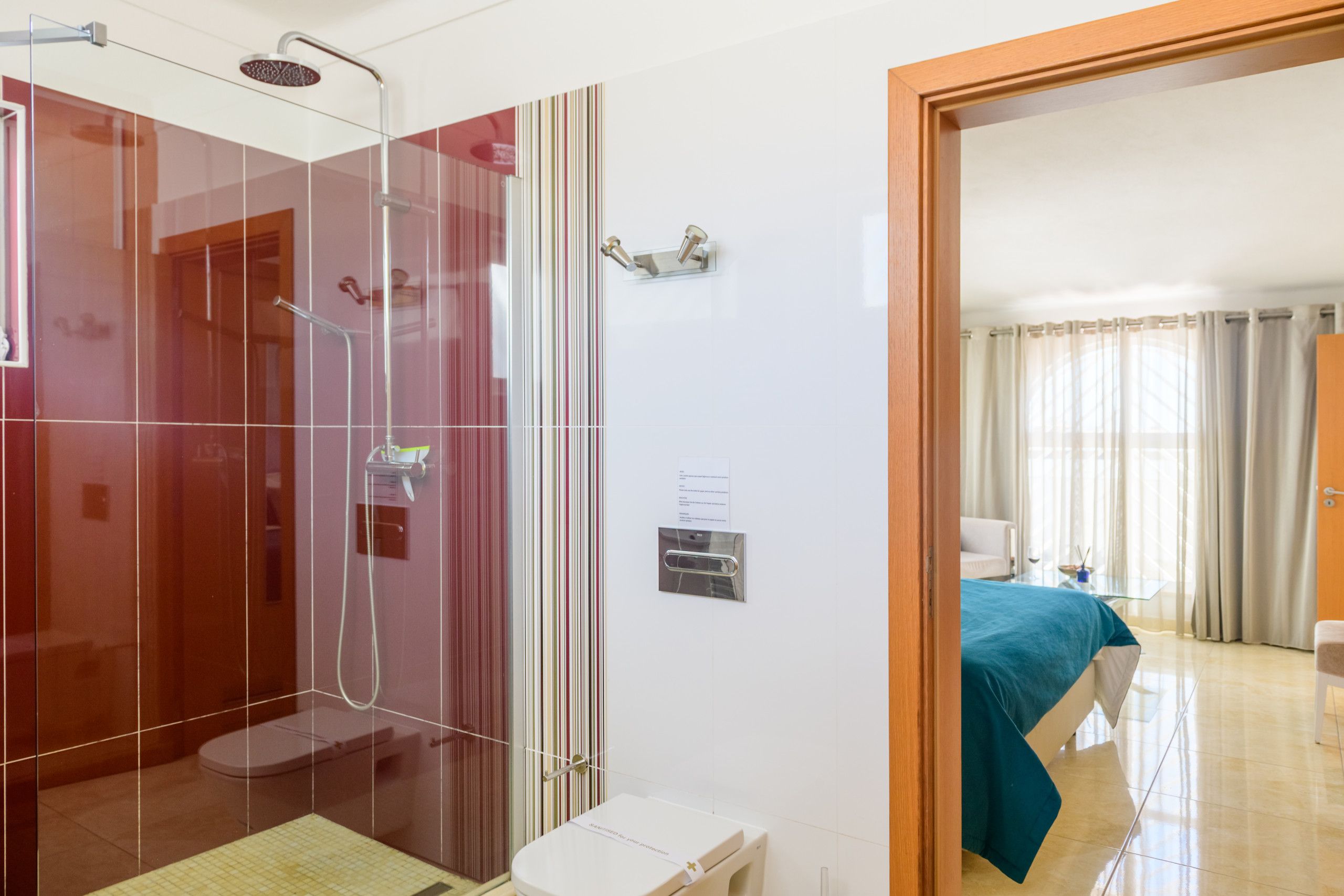 Une salle de bain d’hôtel avec une douche à parois de verre, des toilettes et un lavabo.