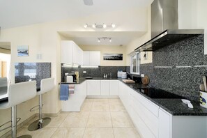 Eine moderne Küche mit weißen Schränken, Granit Arbeitsplatten und Edelstahlgeräten.