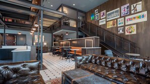 Ein modernes Interieur mit Ledersofas, einer Treppe und Kunstwerken an den Wänden.