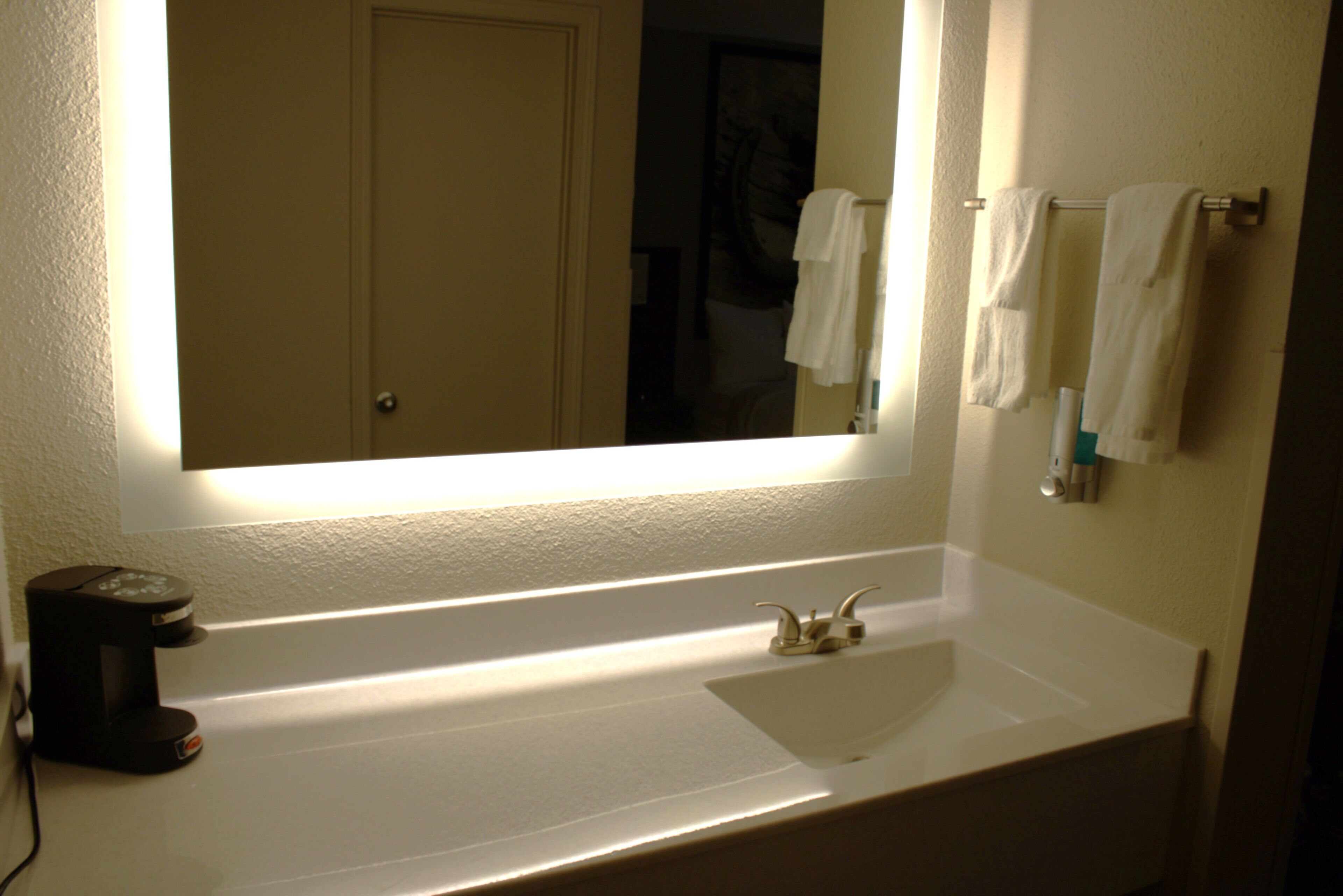Ein Badezimmer mit Waschbecken, Spiegel und Handtuchhalter.