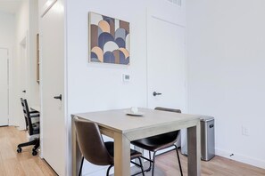 Een moderne eetruimte met een tafel, stoelen en een klein apparaat.