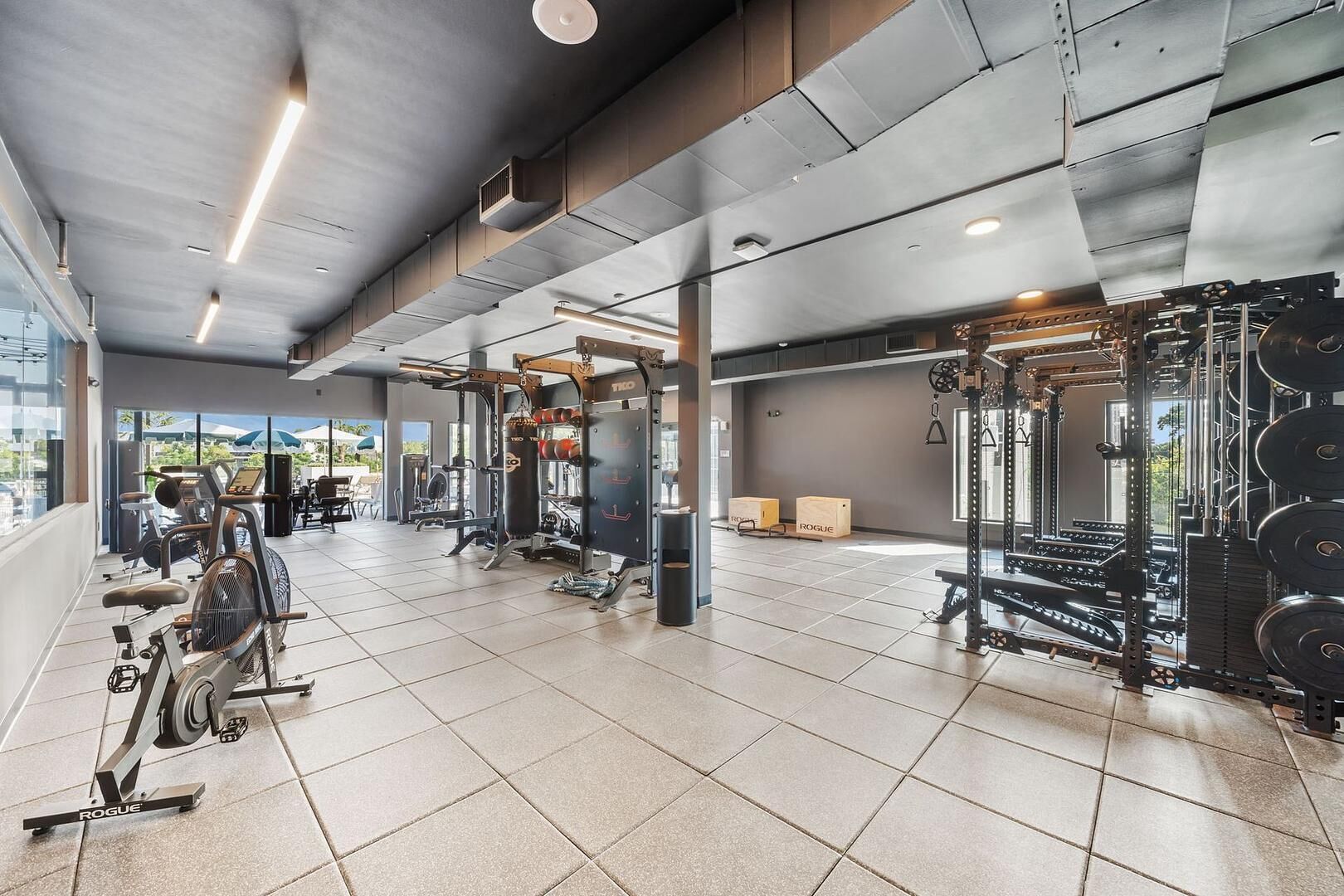 A gym with various exercise equipment, including treadmills and weightlifting stations.