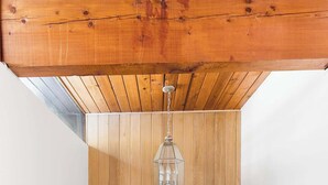 A room with wooden panel walls, a hanging lantern light fixture, and a white bench.