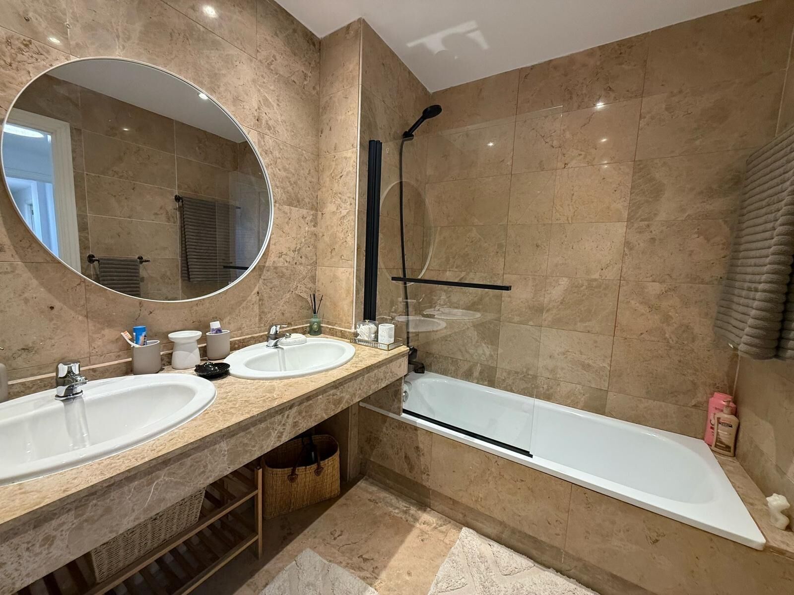 A modern bathroom with two sinks, a large mirror, a shower, and a bathtub.