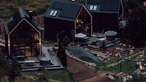 A modern, detached house with a large deck, a fire pit, and a well-maintained garden. - Flowfort View Private Hottub & Sauna Cottagerześko (Stara Kamienica)