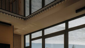 A modern interior with a large window, a wooden staircase, and a hot tub outside. - Flowfort View Private Hottub & Sauna Cottagerześko (Stara Kamienica)