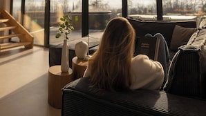 A modern interior with large windows, a staircase, and a sofa with a book. - Flowfort View Private Hottub & Sauna Cottagerześko (Stara Kamienica)