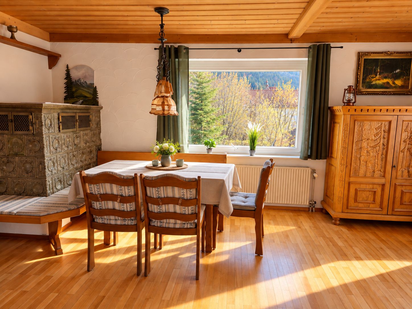 A dining area with a wooden table, chairs, and a window with a view of trees.