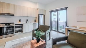 A modern apartment with a kitchen, dining area, and a balcony with a view. - Landing | Spectacular Studio, Courtyard, Gym (Houston)