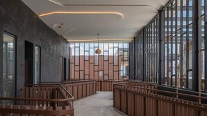 A modern interior with a central corridor, wooden railings, and large windows. - 2BR/2BA Luxury Condo in Amira Tulum Pool, Gym & Prime Location (TULUM)